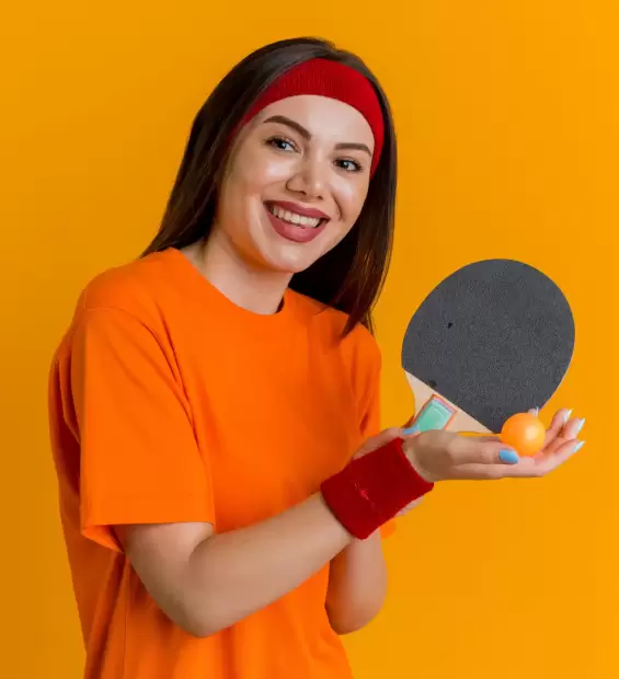 joyful-young-sporty-woman-wearing-headband-wristbands-holding-ping-pong-racket-ball-looking